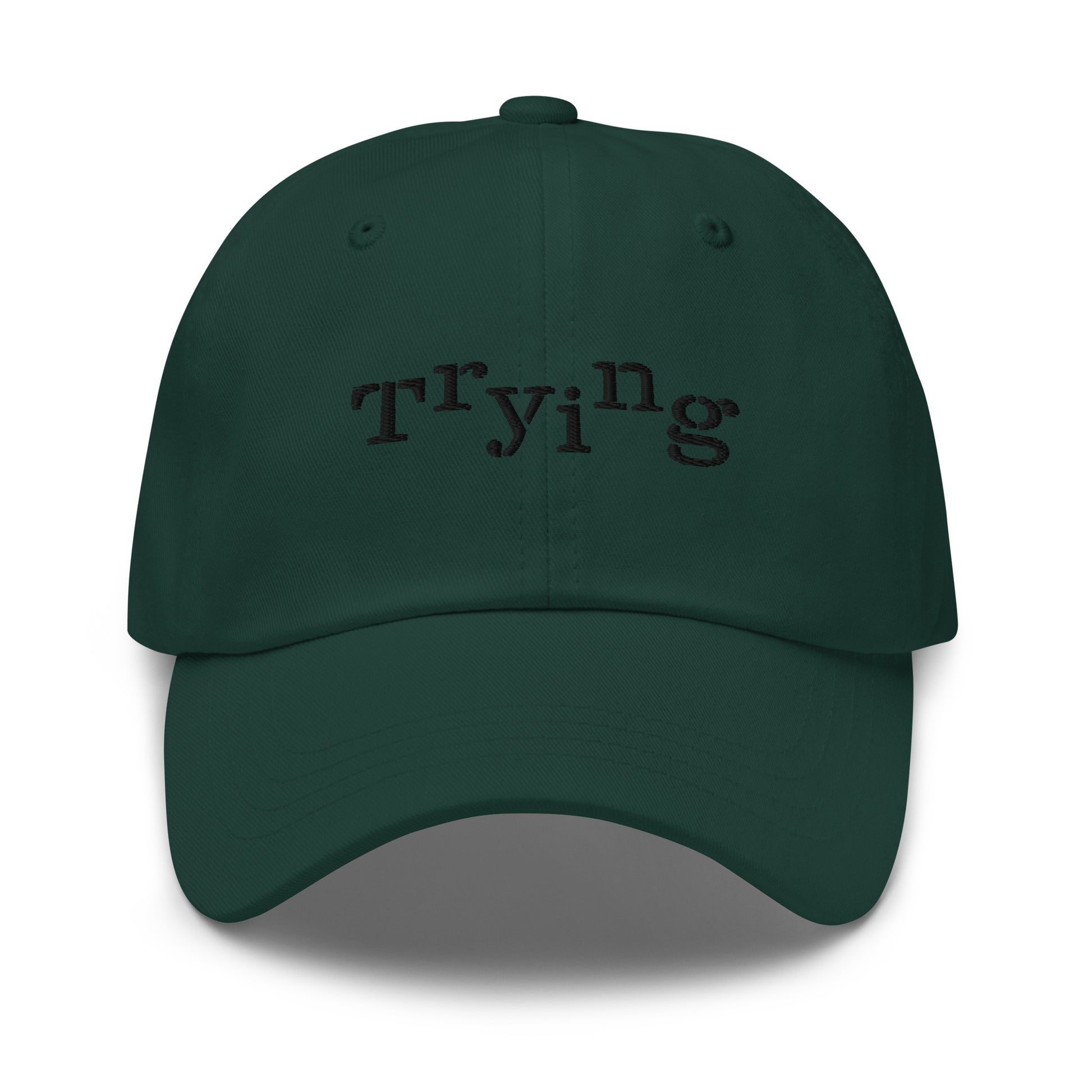 Spruce classic dad hat with black embroidered text that reads ‘Trying,’ designed by queer creators to express mental health and perseverance. Front view, not on model.