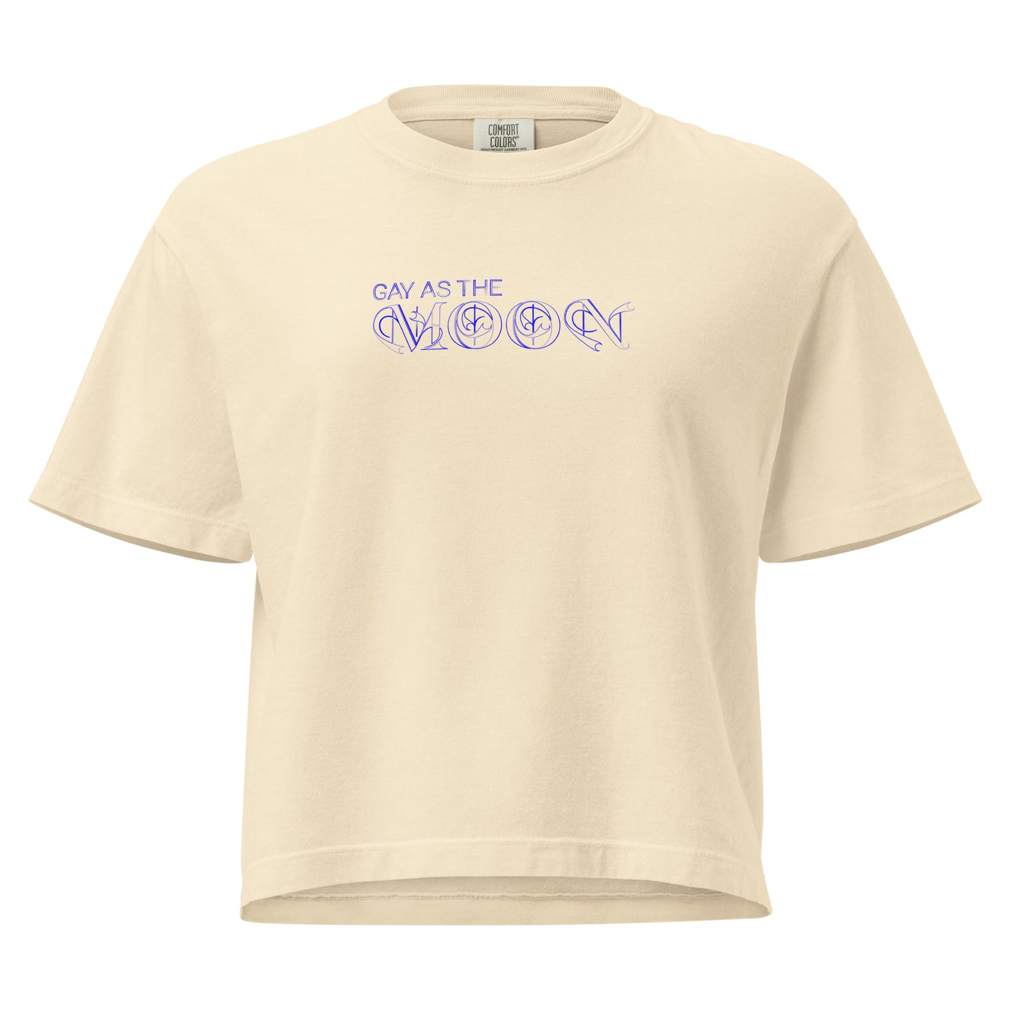 Ivory, boxy T-shirt featuring the phrase ‘Gay as the moon’ in a decorative blue typeface. Playful nod to queer identity and astrology, embracing the idea that astrology is gay. Designed by a small LGBTQ+ owned business. Front of t-shirt. 