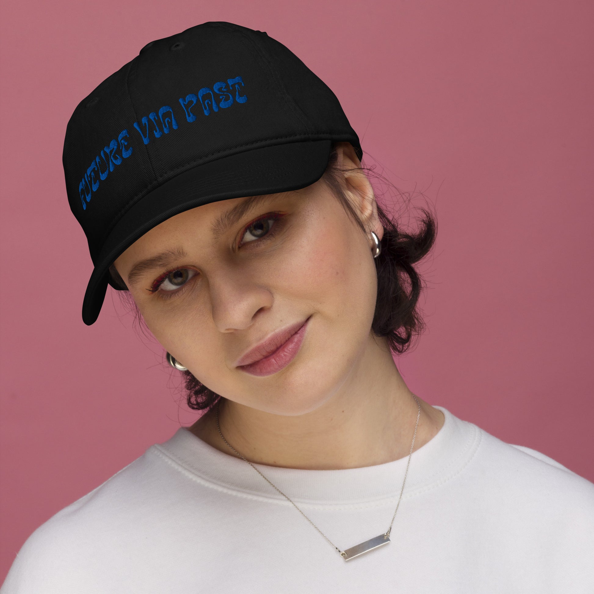 Black dad hat embroidered with the words "FUTURE VIA PAST" in stylized blue lettering, a 12:AM Intuition design. We are shaped by everything behind us. Look forward, while remembering the past. On model. 