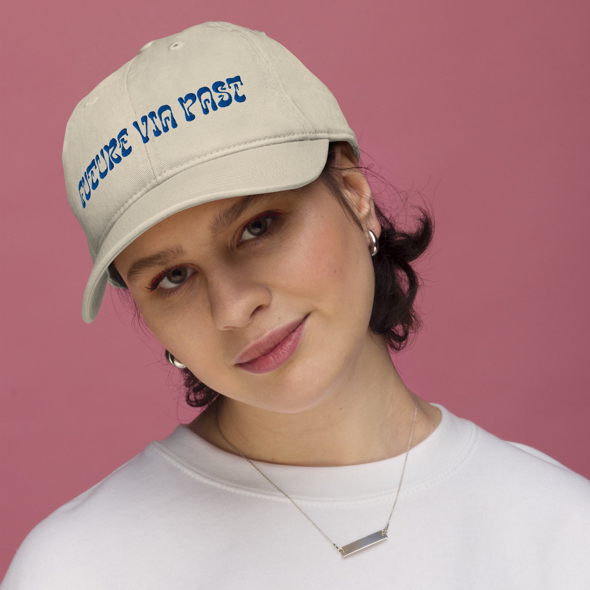 Oyster dad hat embroidered with the words "FUTURE VIA PAST" in stylized blue lettering, a 12:AM Intuition design. We are shaped by everything behind us. Look forward, while remembering the past. On model. 