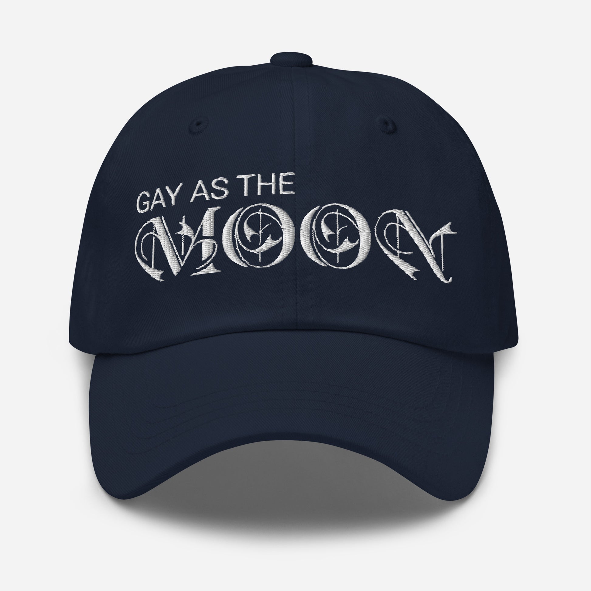 Navy Blue, classic dad hat featuring the phrase 'Gay as the moon' in a white decorative typeface. Playful nod to queer identity and astrology, embracing the idea that the moon is gay. Designed by a small LGBTQ+ owned business. Front of hat.