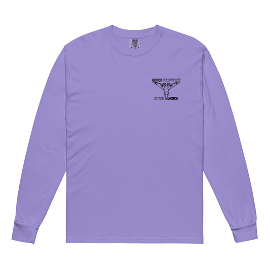 Violet, long-sleeve shirt. Featuring the phrase ‘Queer existence is the agenda’ on the front, ‘here to stay’ on the back. Design is in black, with a butterfly design on the front and an abstract design on the back. Design is in contrast to legislation that is based on eraser of queer people. Designed by a small LGBTQ+ owned business. Front of shirt. 