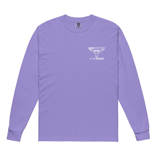 Violet, long-sleeve shirt. Featuring the phrase ‘Queer existence is the agenda’ on the front, ‘here to stay’ on the back. Design is in white, with a butterfly design on the front and an abstract design on the back. Design is in contrast to legislation that is based on eraser of queer people. Designed by a small LGBTQ+ owned business. Front of shirt. 