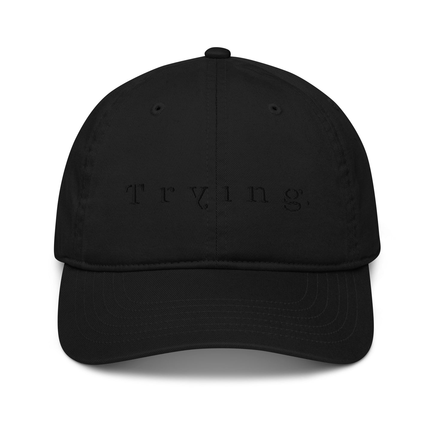 Black dad hat embroidered with the word "Trying." it is a black on black design, in spaced serif lettering — a 12:AM Intuition design honoring the messy middle. 