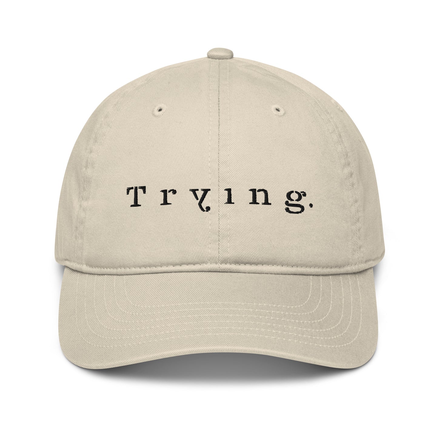 Stone dad hat embroidered with the word "Trying." in spaced serif lettering — a 12:AM Intuition design honoring the messy middle.